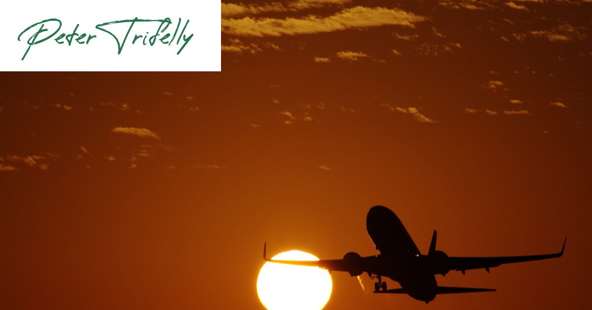 A plane soaring through the sky, representing the concept of being equipped with an "Attitude Indicator" for your business at Peter Trifelly Certified Business Coach