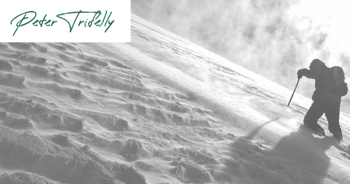 Determined hiker ascending snow-covered peak, motivated by Rocky's words at Peter Trifelly Certified Business Coach